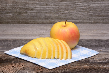 sliced apple on towel over wooden backgroundの写真素材