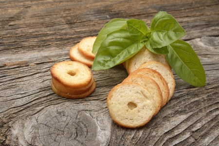 Mini rolls of baked bread and basil isolated on wooden backgroundの写真素材