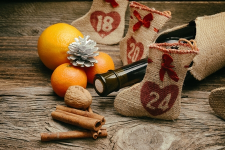Red wine and Christmas ornaments on wooden table on wooden backgroundの写真素材