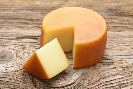 Cheese wheel on wooden tableの写真素材