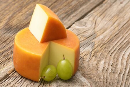 Piece of cheese and grape on wooden boardの写真素材