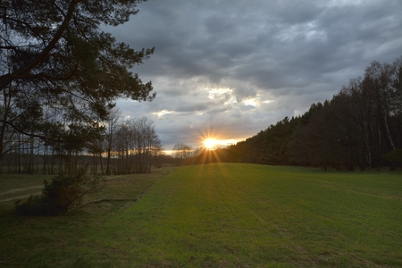 Beautiful sunset over the green large fieldの写真素材