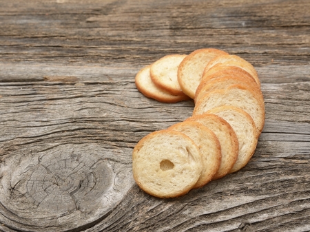 Pile of bite-size Italian crostini isolated on a wooden backgroundの写真素材