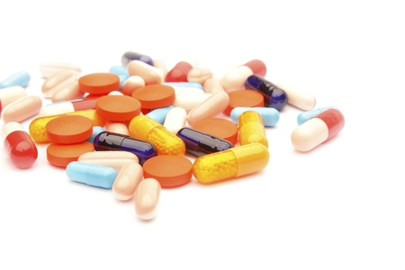 Colored pills, tablets and capsules on a white backgroundの写真素材