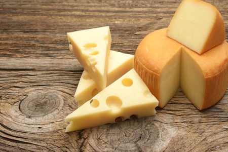 Different types of cheeses arranged as a frame on black board.の写真素材