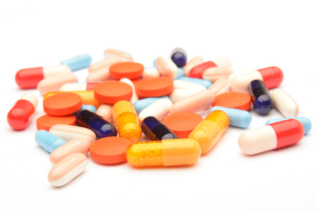 Colored pills, tablets and capsules on a white backgroundの写真素材