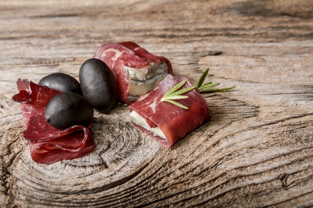 Tasty sliced prosciutto crudo and garlic on a cutting boardの写真素材