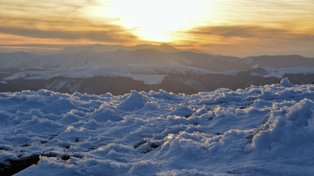 Sunset time in a cloudy day in Ciucas Mountains. The fir forest is covered with snowの写真素材