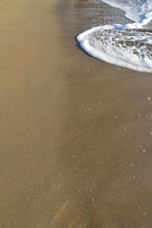 Wave of the sea on the sand beachの写真素材