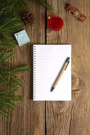 Christmas letter writing on white paper on wooden background with decorationsの写真素材
