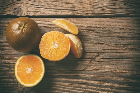 Dark orange isolated on wooden background. Brown oranges.の写真素材