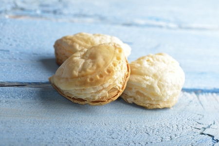 Mini cheese filled baked pies isolated on blue wooden backgroundの写真素材