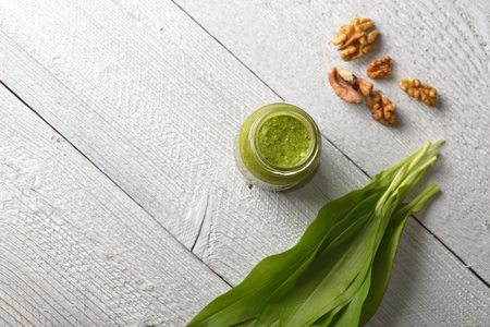 Bear's onion pesto, wild garlic, walnuts and pesto on white wooden backgroundの写真素材