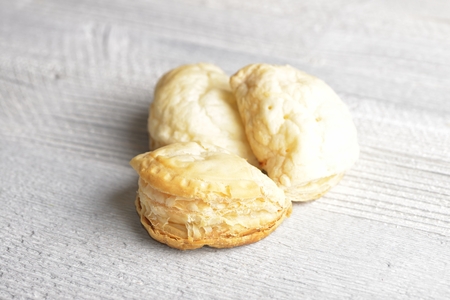 Mini cheese filled baked pies isolated on white wooden backgroundの写真素材