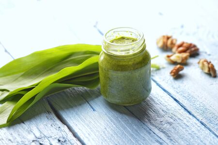 Bear's onion pesto, wild garlic, walnuts and pesto on blue wooden backgroundの写真素材