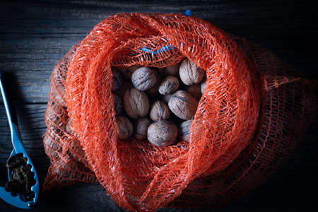 Walnuts in a bag on a wooden backgroundの写真素材