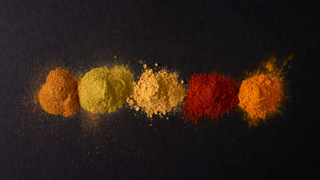 Various spices on black background. Top view with copy space.