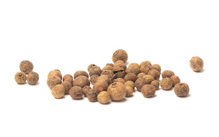 Dried herb, allspice in the olive wood scoop, isolated on whiteの写真素材