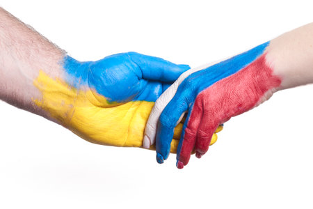 Flags of Ukraine and Russia Flag on hands isolated on white background. Concept of political, economical, social aggressions, disagreement.の写真素材