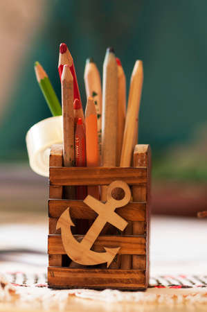 Pencils in a container made of wood. Box decorated with an anchorの写真素材