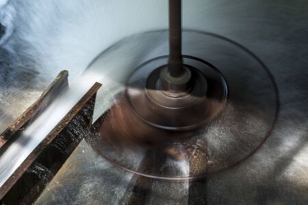 Spinning wheel of a water mill. Horizontal water wheel. Long exposure.の写真素材