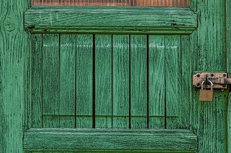 Detail of wooden door. Green painted door with lock.の写真素材