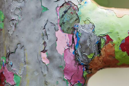 Peeling paint on a metal bar. Multiple layers of colored paint.の写真素材