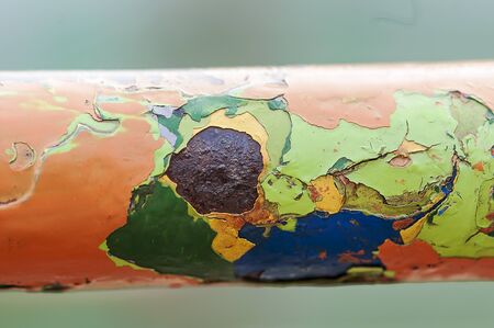 Peeling paint on a metal bar. Multiple layers of colored paint.の写真素材