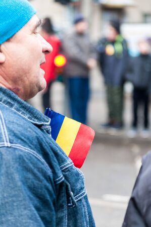 TIMISOARA, ROMANIA - DECEMBER 1, 2017: Man with a flag on his chest pocket at the National Day parade in Romaniaのeditorial素材