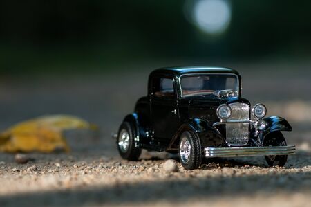 Close-up on a vintage car on a road in a forest. Childhood memories. Shallow depth of field.の写真素材
