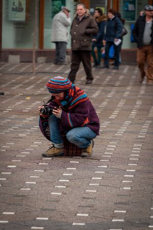 TIMISOARA, ROMANIA - JANUARY 20, 2014: Woman taking a photograph in the cityのeditorial素材