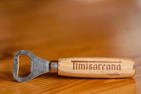 VALIUG, ROMANIA - APRIL 08, 2018: Timisoareana beer bottle opener on a wooden table. Copy space.のeditorial素材