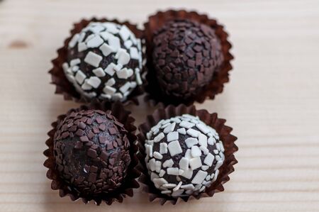 Mini cupcake desserts on a wooden table. White and dark chocolate chips