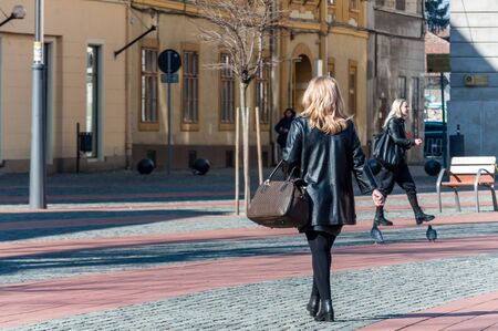 Woman walking on the street, in the city. Real people. View from behind.のeditorial素材