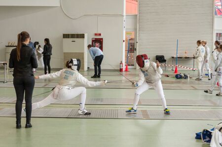 TIMISOARA, ROMANIA - NOVEMBER 12, 2016: Two fencing athletes competing in a matchのeditorial素材