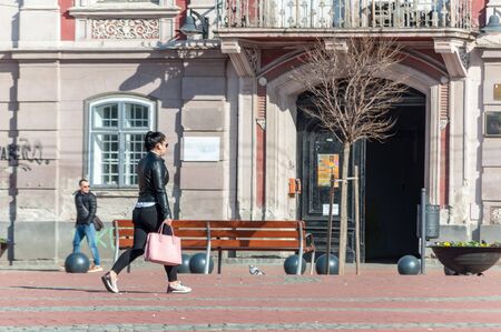 TIMISOARA, ROMANIA - MARCH 15, 2018: Woman walking on the street, in the city. Real people. Rear...