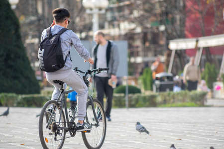 TIMISOARA, ROMANIA - NOVEMBER 17, 2019: Man riding his bicycle in the street. Real people.