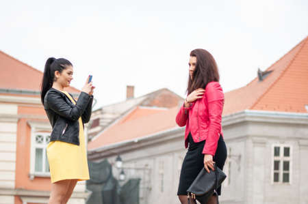 Timisoara, Romania - April 09, 2016: Girls taking a selfie on the street. Real people.のeditorial素材
