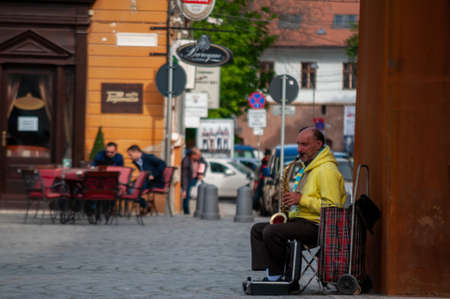 Timisoara, Romania - April 13, 2016: Man playing a saxophone on the street. Real people.