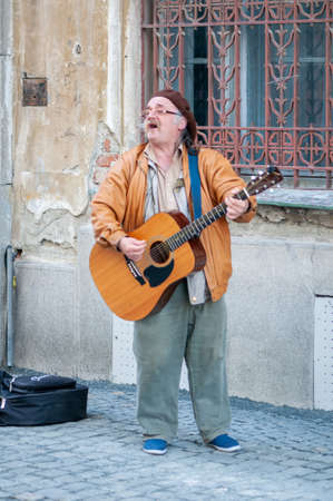 Timisoara, Romania - April 02, 2016: Man singing and playing his guitar in the street. Real people.のeditorial素材