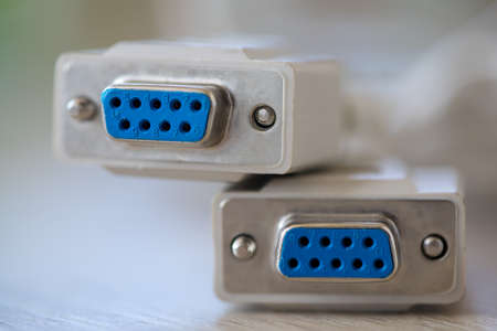 Close-up of a RS-232 serial port. Female to female extension cord on a wooden table.
