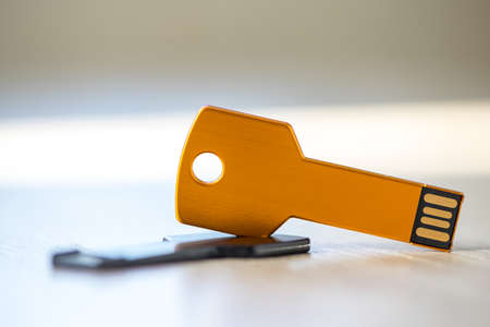 Close-up of a pen drive, flash disk sitting on a disk drive. Key chain shape.の写真素材