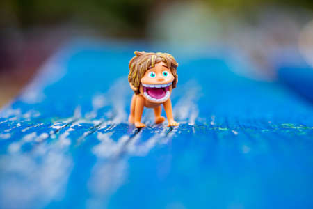 Timisoara, Romania - August 24, 2019: Close-up of a boy figurine sitting on a blue wooden benchのeditorial素材