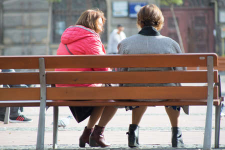 Two women sitting on a bench. Real people.の写真素材