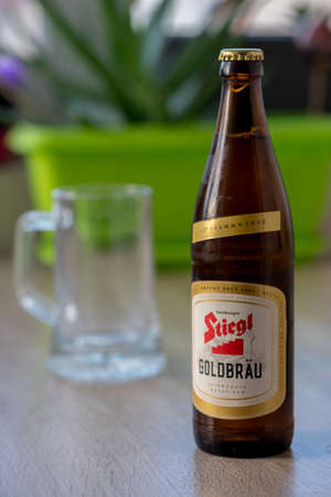 TIMISOARA, ROMANIA - OCTOBER 04, 2019: Stiegl Goldbrau beer bottle and a pint of beer on a wooden table. Made in Austriaのeditorial素材