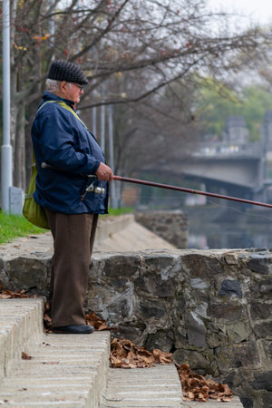 Timisoara, Romania - November 22, 2012: Close-up of  a man fishing in the Bega river. Real people.のeditorial素材