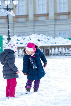 Timisoara, Romania - January 30, 2014: Kids playing with snow in the street. Real people.のeditorial素材
