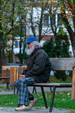 Timisoara, Romania - November 05, 2013: Man sitting on a bench in the street. Real people.のeditorial素材
