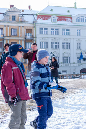 Timisoara, Romania - January 30, 2014: Kids playing with snow in the street. Real people.のeditorial素材