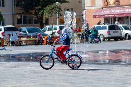 Timisoara, Romania - September 27, 2014: Kid riding his bicycle near a water fountainのeditorial素材